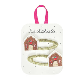 2 gold hair clips with gingerbread houses on them