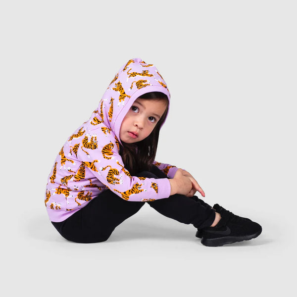 Child sitting profile, wearing purple hoodie with orange tigers throughout