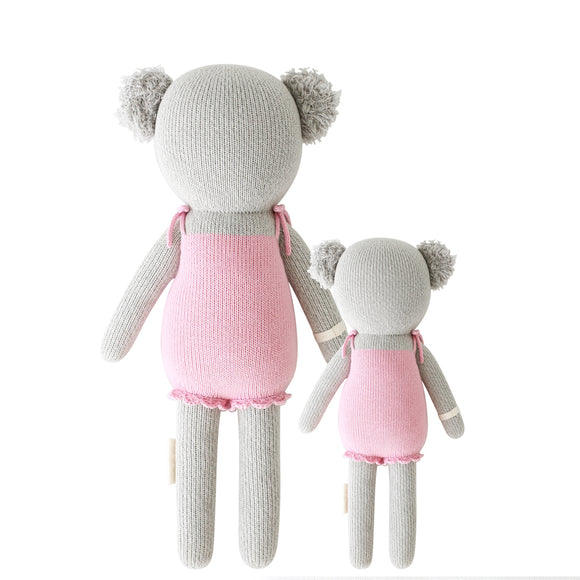 A back shot of the 2 different sized koala stuffies wearing pink dresses