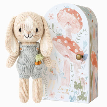 Tiny Henry the Bunny - Handmade knitted bunny toy in gray overalls with a flower, beside a floral mushroom-themed gift box, unique Canadian gift.