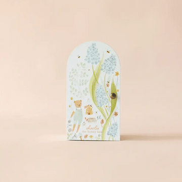 Tiny Charlie the Honey Bear - Rectangular pastel blue box with rounded top, featuring small bear and foliage illustrations, labeled Tiny Charlie the Honey