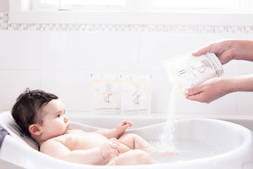 Little Charlie Baby Bath Soak 250g - Baby soaking in white tub with Little Charlie Baby Bath Soak being poured, unique handmade Canadian gift.