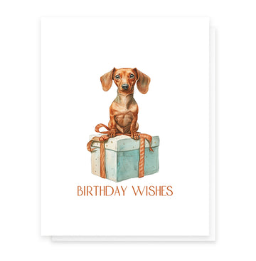 Birthday Wishes Dachshund Card - Handmade Canadian greeting card with a dachshund sitting on a gift box and "Birthday Wishes" text.