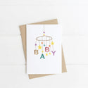 A white card with an illustrated baby mobile with the letters B A B Y and stars on the mobile