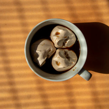 Espresso Cream Skull Lip Balm - White espresso cream skull-shaped lip balms in a gray mug, unique handmade Canadian gift.