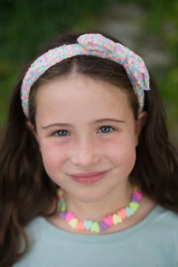 Sweet Tart Heart Necklace & Bracelet Set - Colorful candy heart necklace and bracelet set with pastel beads worn by a smiling young girl.
