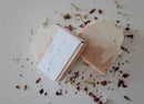 Rosé All Day Soap Bar - Light pink rectangular soap bar with rounded edges, handmade texture, wrapped in white label, surrounded by dried flower.