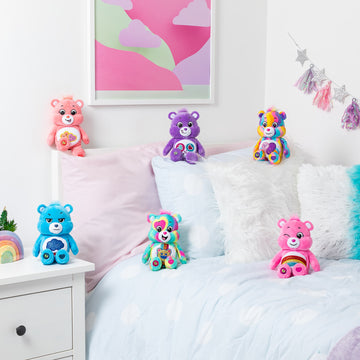 Care Bears - Fun Size Sparkle Plush - Set of six colorful handmade Canadian Care Bears plush gifts on a bed with pastel pillows and decor.