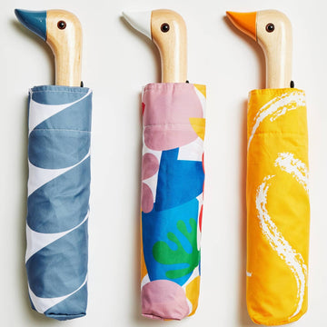 Original Duckhead Umbrellas - Three handmade Canadian Original Duckhead umbrellas with wooden duck handles and colorful fabric sleeves in blue,.