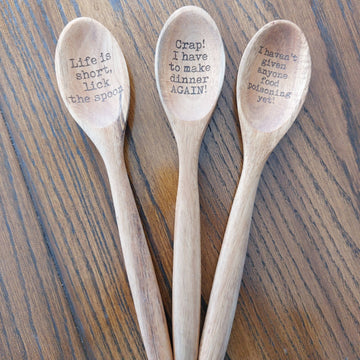 Funny Humor Laser Engraved Wooden Spoon - Three light wood spoons with laser-engraved humorous phrases arranged on a wooden surface.