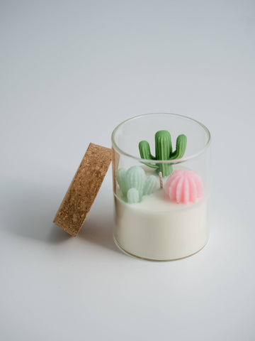 Cactus Candle | Soy Blend Candle: Beach Vibe - Clear glass candle jar with creamy white soy wax, featuring green cactus and pink sea urchin-shaped decorative wax pieces,.