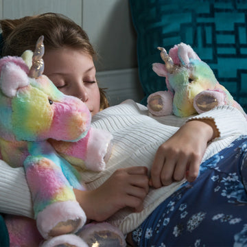 Marshmallow Zoo - 13" Fro-Yo Unicorn - Plush 13" unicorn with pastel rainbow fur, silver horn, and soft pink hooves, cuddled by a child.