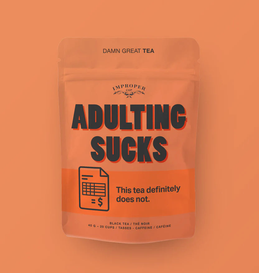 A red bag with black text reading "ADULTING SUCKS" with an illustration of a bill next to "This tea definitely does not"