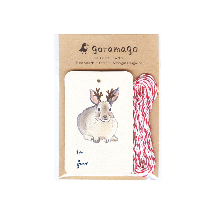 A white gift tag with a bunny facing forward with antlers. Below the bunny is black text reading "to" and "from". Next to the gift tags are red and white twine.