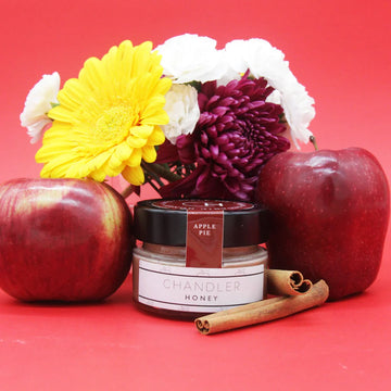 Apple Pie Honey (Chandler Honey) - Small jar of Canadian Chandler Honey Apple Pie flavor with fresh apples, cinnamon sticks, and colorful flowers, unique.