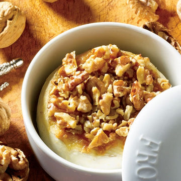 Maple Walnut Brie Topping - Round brie cheese topped with chunky maple walnut pieces in white ceramic dish, unique handmade Canadian gift.