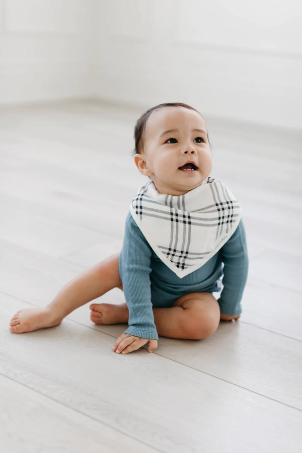 A baby wearing the black and white plaid patterned bandana bib