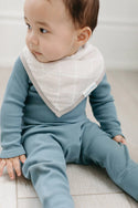 A baby wearing the beige bandana bib