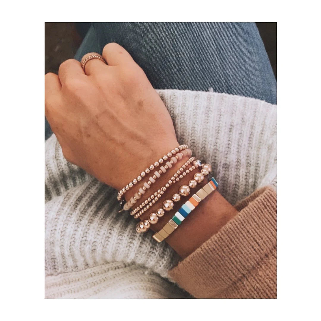 A person wearing the Caramel and Colour Puzzle Bracelet alongside other bracelets