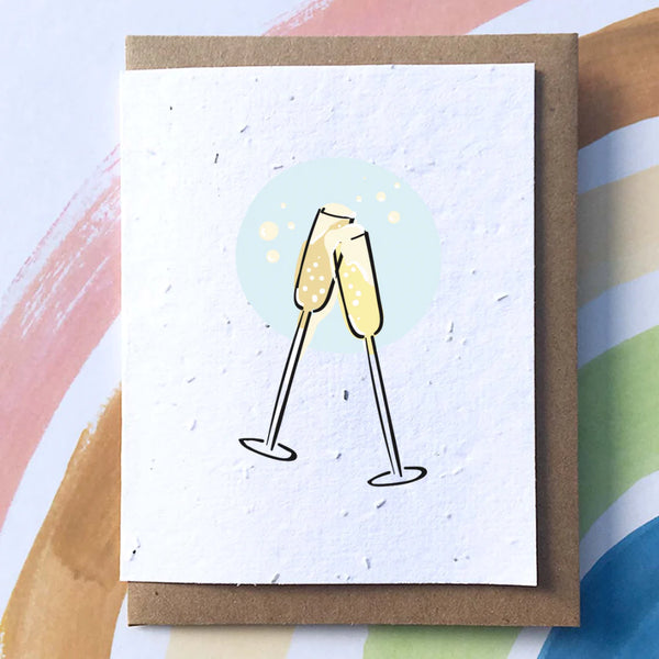 A white card with a brown envelope. On the card there are two illustrated champagne glasses together in a bubble