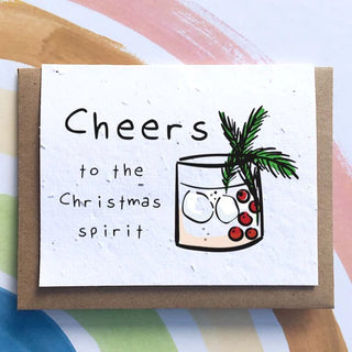 A white card with a cup of liquor with the words “Cheers to the Christmas Spirit”