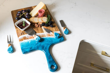 Lynn & Liana Resin Coated Cheese Knife Set - Unique handmade Canadian cheese board with ocean blue resin-coated handle, styled with cheese and grapes, perfect gift.