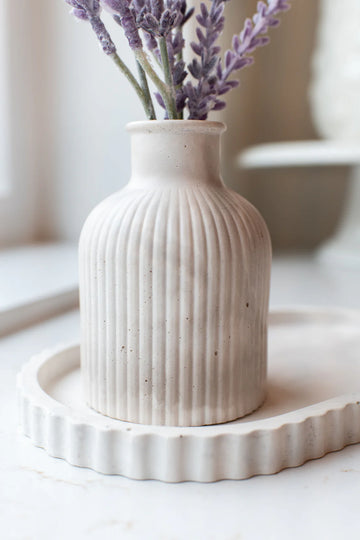 Lynn & Liana Limestone Bud Vase - Creamy white limestone bud vase with vertical ribbed texture and rounded silhouette on fluted tray.
