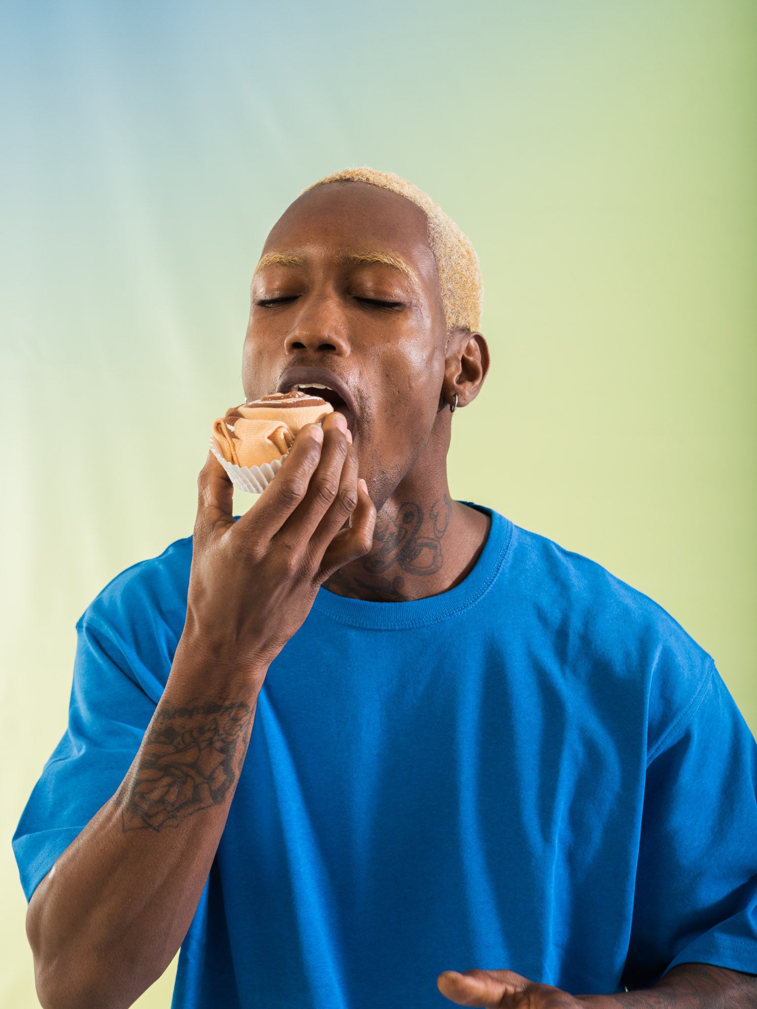 A model wearing a blue shirt, pretending to eat the folded socks