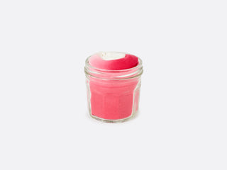 A jam jar with a red gingham lid with pink socks inside