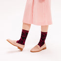 A model wearing the socks with salmon coloured loafers