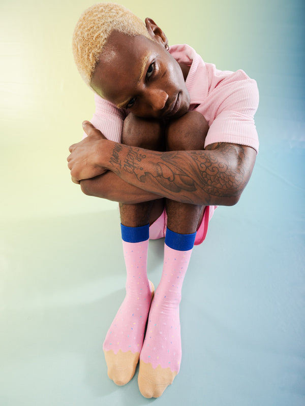 A model wearing the socks while sitting down and hugging his knees