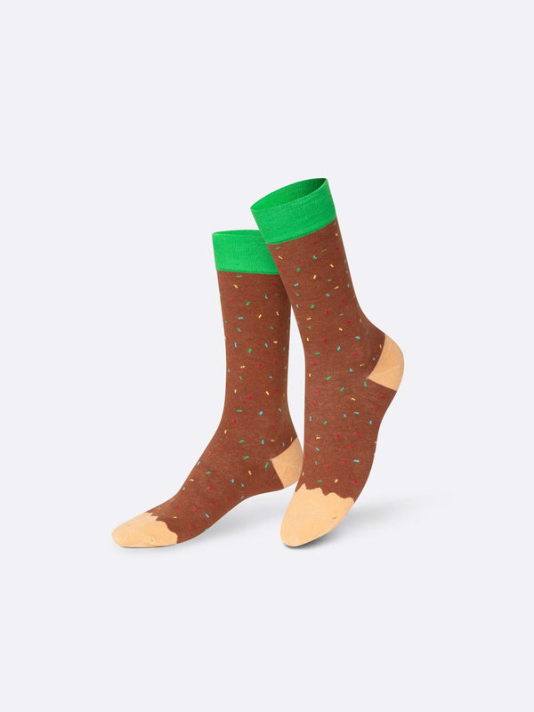Multicoloured socks with beige toes and heels, brown with green red and yellow sprinkles shins and a green stripe on the calf