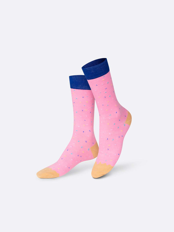 Multicoloured socks with beige toes and heels, pink with blue and white sprinkles ankles and shins and a blue stripe on the calf