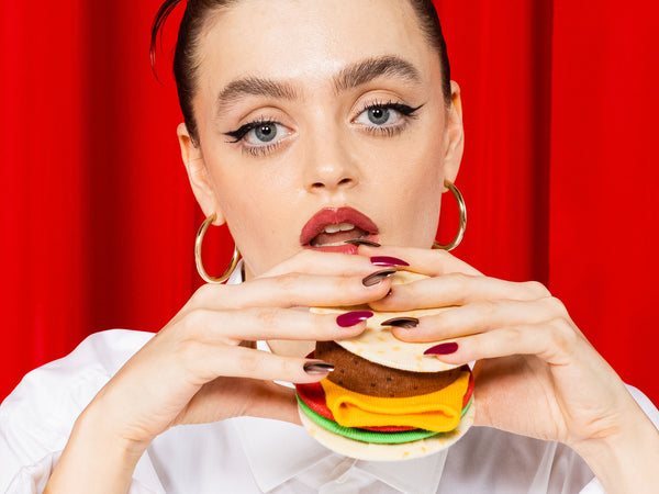 A model holding the burger pretending to eat it