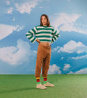 A model wearing the socks in front of an artificial sky backdrop