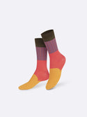Multicoloured socks with an orange toe and bridge, red heel and ankle, purple and red striped shin and a black top