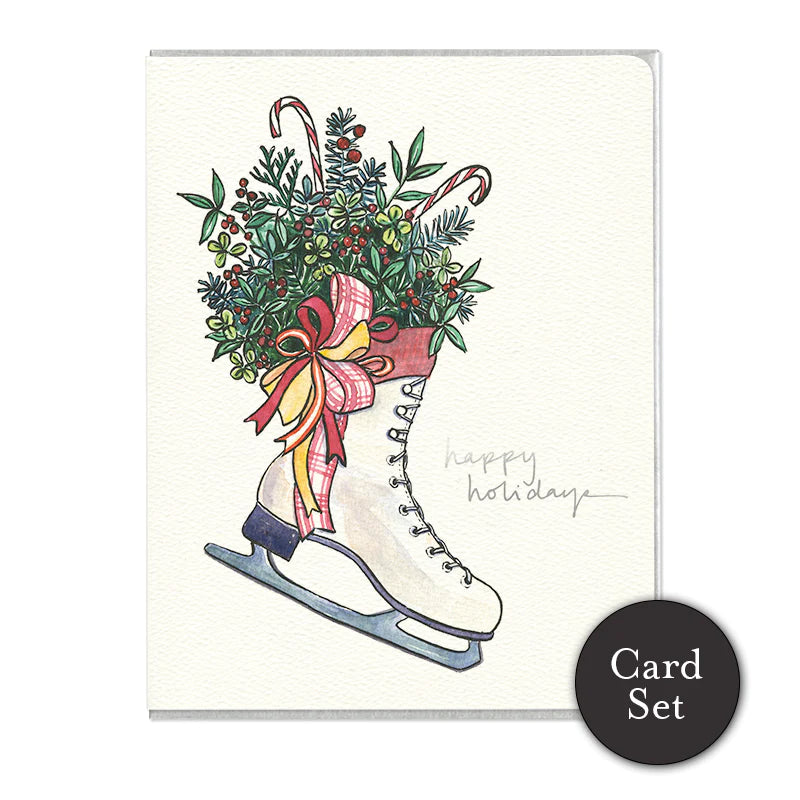 A white card with a white skate filled with holly, pine and candy canes next to "happy holidays" written in silver font. 