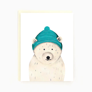 A white card with a polar bear wearing a blue toque with holes for his ears.