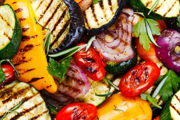 Grilled Vegetable Seasoning - Grilled mixed vegetables with char marks showing red peppers, zucchini, yellow squash, red onion, and parsley garnish,.
