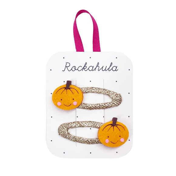Little Pumpkin Bag - Set of two glittery gold hair clips with smiling orange pumpkin decorations on white card labeled Rockahula.