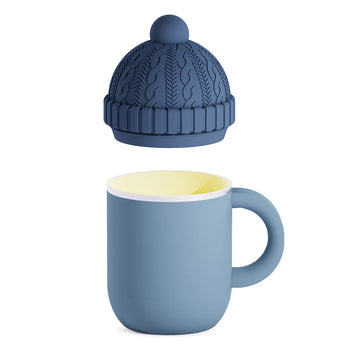 Blue Happy Hats Mug - Blue ceramic mug with rounded handle and removable knit-patterned silicone lid with pom-pom top.