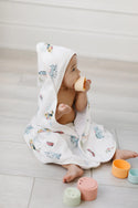 A baby wearing a train patterned hooded towel
