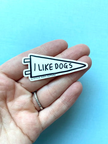 I Like Dogs Vinyl Sticker - White triangular vinyl sticker with "I Like Dogs" text held in hand, unique handmade Canadian gift accessory.