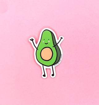 An illustrated smiling avocado on a pink surface