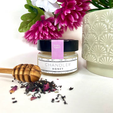 Earl Grey Honey (Chandler Honey) - Small jar of Chandler Honey Earl Grey with wooden honey dipper and loose tea leaves, styled as a unique handmade Canadian.
