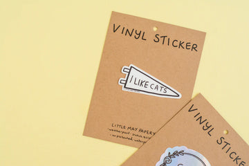 I Like Cats Vinyl Sticker - White vinyl sticker shaped like a speech bubble with black text saying "I like cats" on brown kraft paper backing.