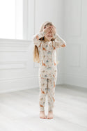 A girl wearing the Baby Dinomite 2-pc Pajama Set by LouLou Lollipop