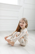  A girl wearing the Baby Dinomite 2-pc Pajama Set by LouLou Lollipop