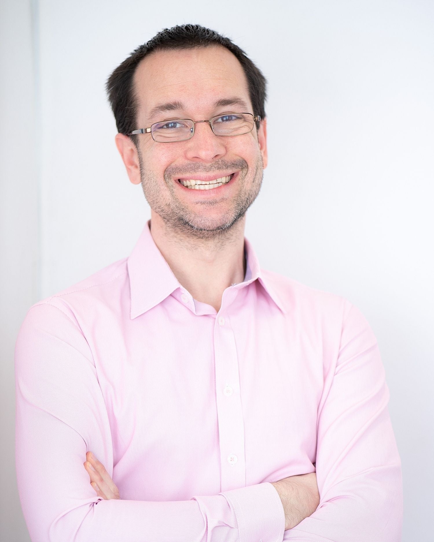 Pawel Kosicki in pink shirt smiling at camera