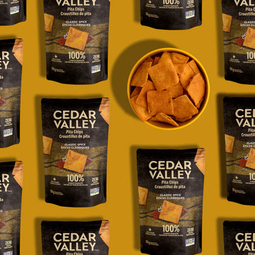 Cedar Valley Pita Chips - Cedar Valley Canadian handmade pita chips in black packaging with bowl of crispy triangular chips, unique gourmet gift.